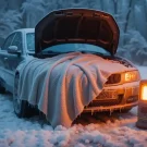 ماشین یخ زده با پتو حرارتی و بخاری در یک محیط برفی