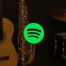 تصویری از لوگو اسپاتیفای در کنار چند گیتار